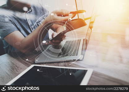 creative working with mobile phone and digital tablet and laptop computer on wooden desk in modern office with virtual icon diagram