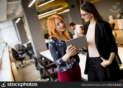 Creative young female executives using digital tablet in office