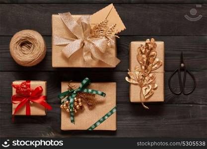 Creatively wrapped and decorated christmas presents in boxes on dark wooden background.Top view from above. Flat lay.