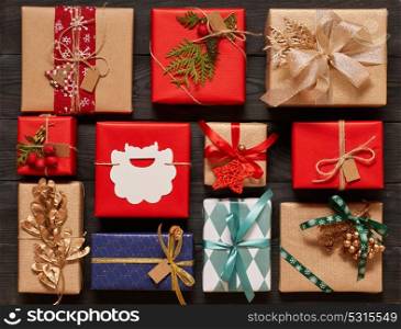 Creatively wrapped and decorated christmas presents in boxes on dark wooden background.Top view from above. Flat lay.