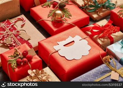 Creatively wrapped and decorated christmas presents in boxes on dark wooden background. Flat lay.