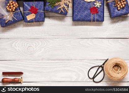 Creatively wrapped and decorated christmas presents in boxes on white wooden background.Top view from above.