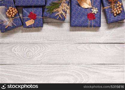 Creatively wrapped and decorated christmas presents in boxes on white wooden background.Top view from above.