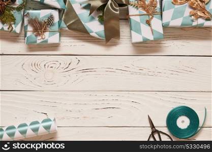 Creatively wrapped and decorated christmas presents in boxes on white wooden background.Top view from above.