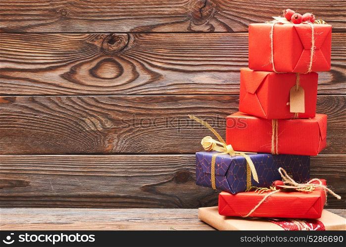 Creatively wrapped and decorated christmas presents in boxes on wooden background. Copy space.