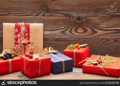 Creatively wrapped and decorated christmas presents in boxes on wooden background. Copy space.