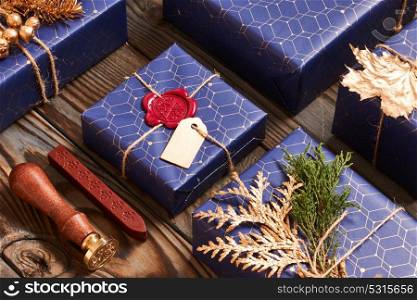 Creatively wrapped and decorated christmas presents in boxes on wooden background. Flat lay.