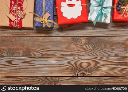 Creatively wrapped and decorated christmas presents in boxes on wooden background.Top view from above. Copy space.