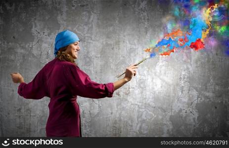 Creativity and art. Young woman painter with brush and colorful splashes above