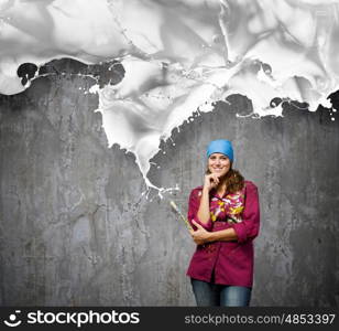 Creativity and art. Young woman painter with brush and white splashes above