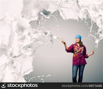 Creativity and art. Young woman painter with brush and white splashes above