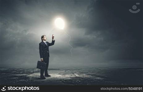 Creativity and brainstorming. Young businessman pointing at balloon. Idea concept