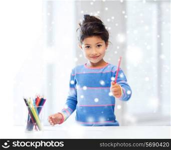 creativity, childhood and people concept - smiling little girl with pencils drawing at home