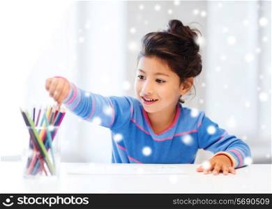 creativity, childhood and people concept - smiling little girl with pencils drawing at home