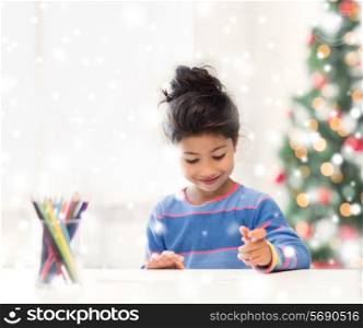 creativity, childhood, christmas and people concept - smiling little girl with pencils drawing at home
