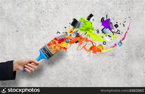 Creativity concept. Close up of business person hand holding paint brush
