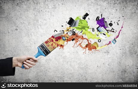 Creativity concept. Close up of business person hand holding paint brush