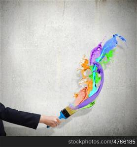Creativity concept. Close up of business person hand holding paint brush