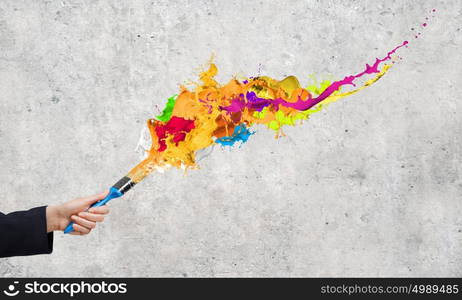 Creativity concept. Close up of business person hand holding paint brush