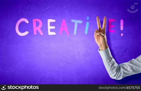 Creativity concept. Creative word with fingers instead of letter v