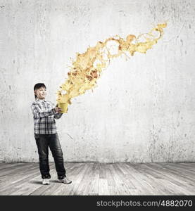 Creativity concept. Cute boy splashing colorful paint from bucket