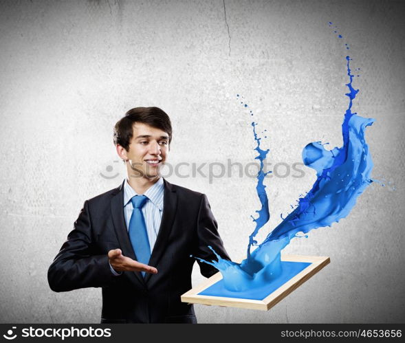 Creativity concept. Handsome businessman holding frame with colorful splashes