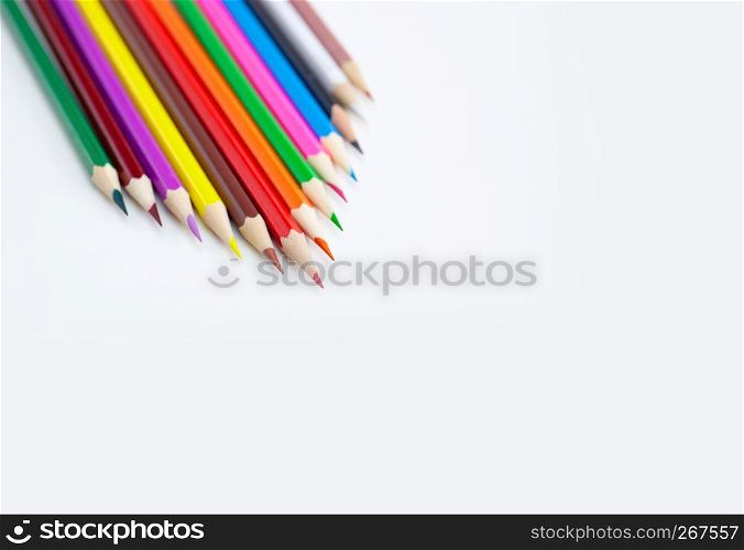 Creativity concept of art and drawing, Triangle shape of multi-colored crayon pencils isolated on white background with copy space. View from above, For banner poster design.