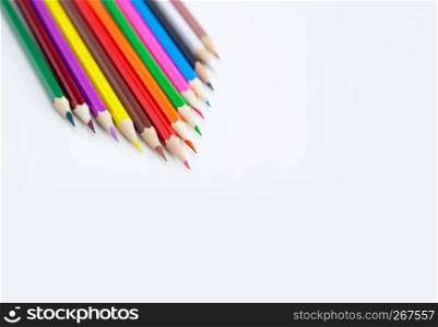 Creativity concept of art and drawing, Triangle shape of multi-colored crayon pencils isolated on white background with copy space. View from above, For banner poster design.
