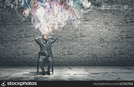 Creativity concept. Thoughtful businessman with colorful fumes above head