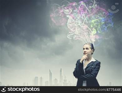 Creativity concept. Thoughtful businesswoman with colorful fumes above head