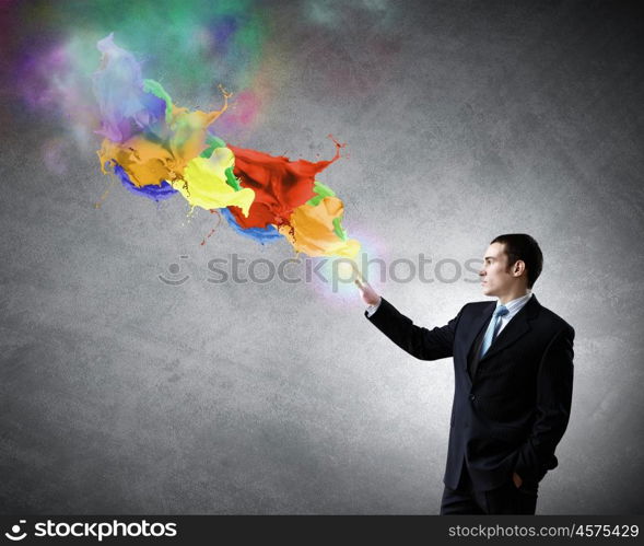 Creativity concept. Young businessman in suit and colorful splashes