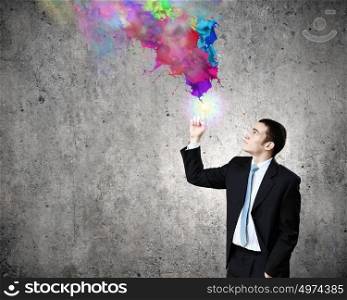 Creativity concept. Young businessman in suit and colorful splashes