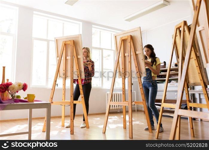 creativity, education and people concept - group of woman artists or students painting still life on easels at art school studio. woman artists or students painting at art school