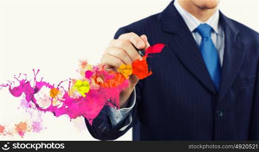 Creativity in business. Businessman against white background drawing colorful splashes with marker