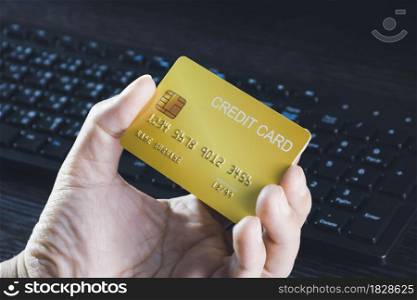 Credit card mockup in the hand with computer keyboard background