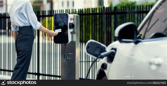 Credit card payment for eco-friendly clean and sustainable energy for electric vehicle at charging station. Progressive woman pay for charging point to power his electric rechargeable vehicle.. Progressive woman pay for charging point to power electric rechargeable vehicle.