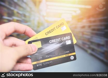 credit card shopping in the supermarket / hand holding credit card payment