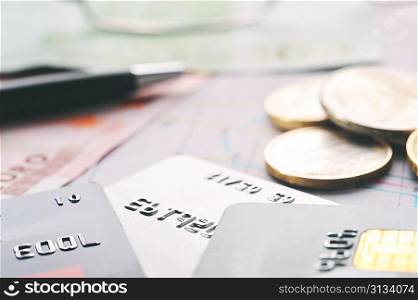 Credit cards, black pen and money on table close up