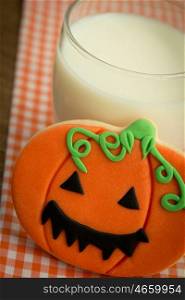Creepy Halloween cookie next to a milk glass. Beautiful pumpkin