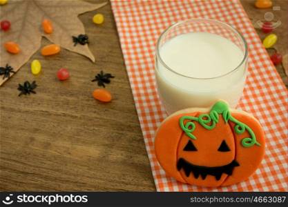 Creepy Halloween cookie next to a milk glass on a wooden table