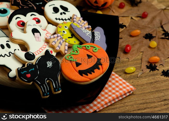 Creepy Halloween cookies and candies on a wooden table