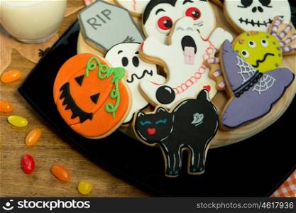 Creepy Halloween cookies next to a milk glass on a wooden table
