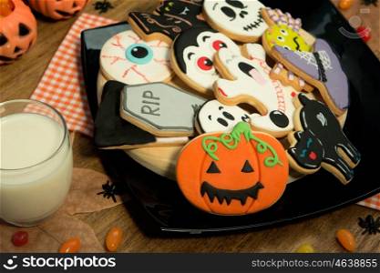 Creepy Halloween cookies next to a milk glass on a wooden table