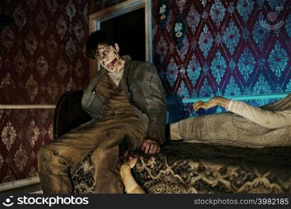 Creepy scary zombie on bed looking at camera. Halloween horror film. Post apocalyptic concept. Zombie sitting on bed looking at camera