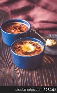 Creme brulee in the pots on the wooden table