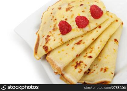 Crepe on a plate with a raspberry. A detailed photo fried thin pancake.Isolated on white