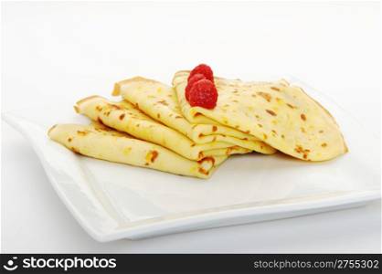 Crepe on a plate with a raspberry. A detailed photo fried thin pancake.Isolated on white