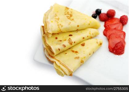Crepe on a plate with a strawberry, a raspberry and a bilberry. It is isolated on a white background.