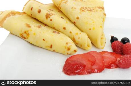 Crepe on a plate with a strawberry, a raspberry and a bilberry. It is isolated on a white background.