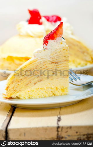 crepe pancake cake with whipped cream and strawberry on top